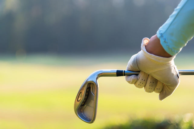 female golfer holding an golf stick behind his body