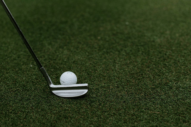 A golf ball on a field about to be putt