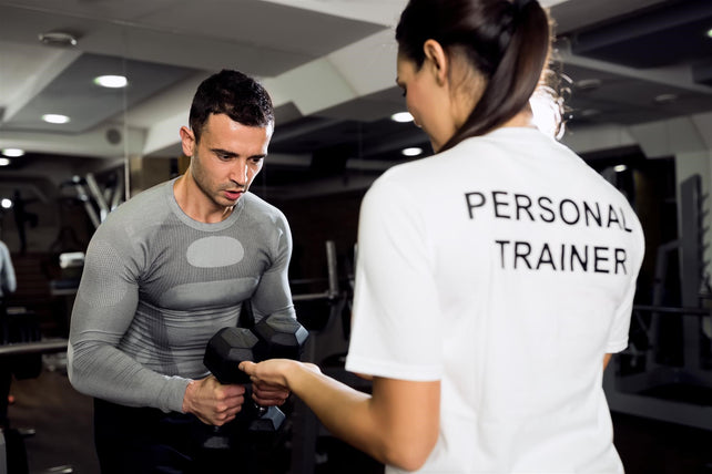 Golfer lifting weights with a trainer