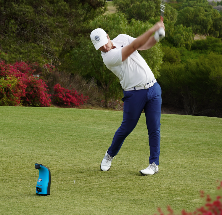 golfer mid swing in front of a foresight launch monitor golfer mid swing in front of a foresight launch monitor