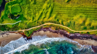 bird&#039;s eye view of golf course by the beach