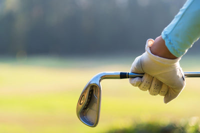 female golfer holding an golf stick behind his body
