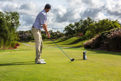 A golf launch monitor set up outdoor to analyse swings.