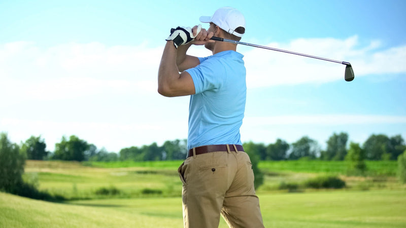 golf player hitting ball in draw position at course