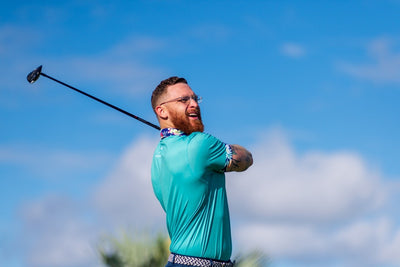 man after swinging golf club