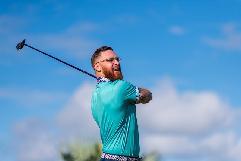 man after swinging golf club