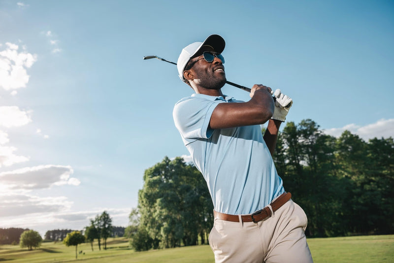 Smiling african american man playing golf