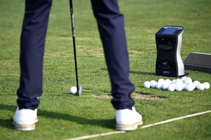 A man on the driving range using a GCQuad Launch Monitor